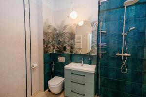 une salle de bain avec toilettes, lavabo et miroir dans l'établissement Resort Hevenia Mrzeżyno 4, à Mrzeżyno 10 autres photos