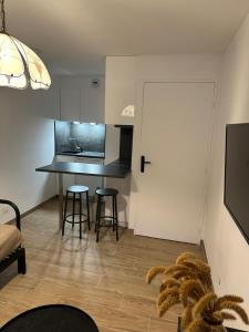 a kitchen with a table and stools in a room at Le Sarsour Appartement Strasbourg Centre in Strasbourg +5 photos