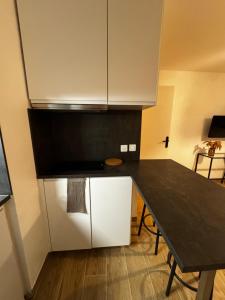 a kitchen with a black counter top and a table at Le Sarsour Appartement Strasbourg Centre in Strasbourg