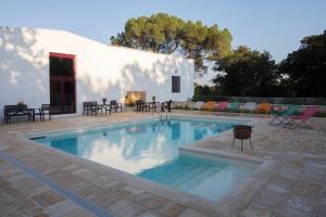 a swimming pool in front of a white building at Masseria Ferri in Ostuni