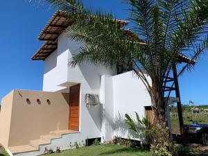 ein Haus mit einer Palme davor in der Unterkunft Casa Branca Maraú in Taipu