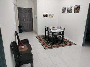a dining room with a table and chairs and a door at Ammara Homestay 2 Emerald Avenue Brinchang in Brinchang