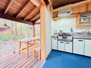 a kitchen with a table and a counter top at Forestalk House in Nagano