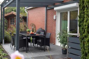 a patio with a table and chairs on a patio at FeWo Cessna, elegante Wohnung, 2 Schlafzimmer, überdachte Terrasse in Cloppenburg