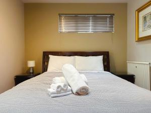 a bedroom with a bed with towels and a window at Apartment On Star Unit 1 in Sandy Bay