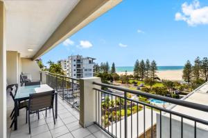 un balcone con tavolo e sedie e vista sulla spiaggia di Oceanfront 3-Bed Retreat with Pool-Steps to Beach a Caloundra