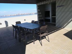 a table and chairs on a balcony with the ocean at Alojamiento en Departamento de Lujo in Encarnación