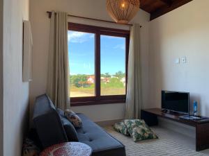 ein Wohnzimmer mit einem blauen Sofa und einem Fenster in der Unterkunft Casa Branca Maraú in Taipu