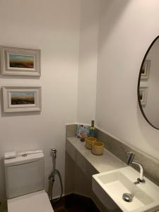 ein Badezimmer mit Toilette, Waschbecken und Spiegel in der Unterkunft Casa Branca Maraú in Taipu + 21 Fotos