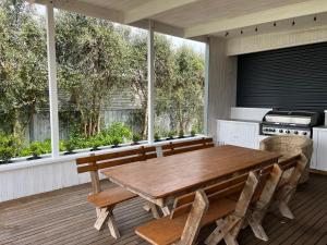 een keuken met een houten tafel en stoelen op een terras bij Saltwater Bungalow - WiFi in Robe