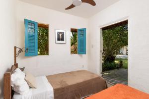 - une chambre avec 2 lits et des fenêtres à volets bleus dans l'établissement Casa Urucum - Recife - Casa Ecológica, à Camaragibe 24 autres photos