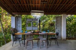 une table et des chaises en bois sur une terrasse dans l'établissement Casa Urucum - Recife - Casa Ecológica, à Camaragibe