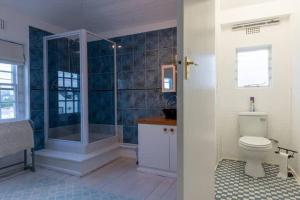 a bathroom with a shower and a toilet at Langebaan 4 Bedroom Holiday Home in Langebaan +17 photos