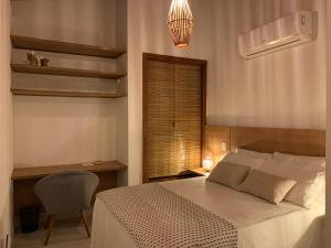 ein Schlafzimmer mit einem Bett, einem Stuhl und einem Fenster in der Unterkunft Casa Branca Maraú in Taipu