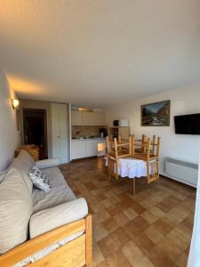 salon z kanapą i stołem w obiekcie HOUNTANET appart 5 personnes vue montagne avec jardin w mieście Saint-Lary-Soulan