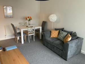a living room with a couch and a table at Light and airy cosy bungalow in Draycott