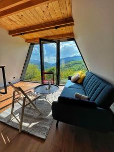 a living room with a blue couch and a table at Kucica na Brdu in Brda