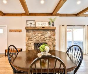 a dining room with a table and chairs and a stone fireplace at Mountain Cabin with Scenic Views and Hot Tub in Windham