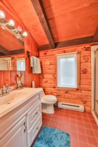 ein Badezimmer mit Toilette und Waschbecken und einem Fenster in der Unterkunft 4 Bedroom Log Cabin with Stream and Great Location in Lanesville