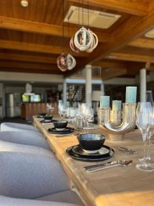 un lungo tavolo in legno con piatti e bicchieri da vino di Sunlight City Villa a Villach