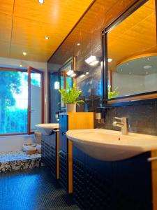 un bagno con due lavandini e un grande specchio di Sunlight City Villa a Villach