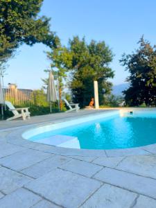 piscina blu con tavolo e ombrellone di Sunlight City Villa a Villach