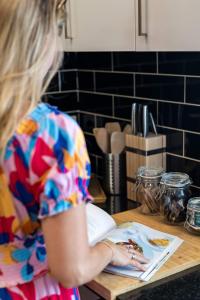 a woman sitting at a table with a plate of food at Dalton Cottage - Charm & Convenience in Orange