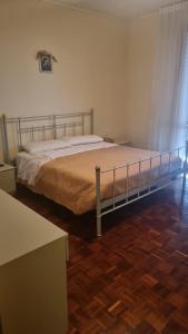 a bed in a bedroom with a wooden floor at Viale Ancona by Ospitaci in Foligno