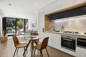 a kitchen and living room with a table and chairs at Fabulous 1-Bed with Pool and Private Courtyard DUPLICATE in Melbourne