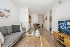 a living room with a couch and a table at Fabulous 1-Bed with Pool and Private Courtyard DUPLICATE in Melbourne