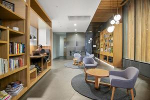 a woman sitting at a desk in a library with a laptop at Fabulous 1-Bed with Pool and Private Courtyard DUPLICATE in Melbourne