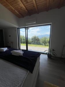 Un dormitorio con una cama y una ventana grande. en Kucica na Brdu, en Brda