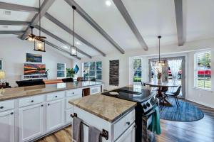 a kitchen with white cabinets and a table in it at Peach Street Retreat - Fire Pit and Close to Main St in Fredericksburg