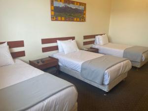 a hotel room with three beds in a room at Hotel Cienciano in Cusco +7 photos