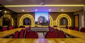 a conference room with a long table and red chairs at Business Palas Otel in Kocaeli