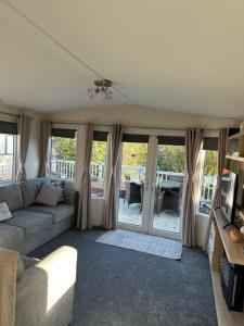 a living room with a couch and a table at Anglers Rest, with Hot Tub and Private Fishing Peg in Tattershall