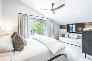 a white bedroom with a bed and a tv at Luxury Home with Vail Mountain View in Vail