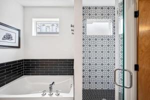 a bathroom with a white tub and a black and white tiles at 3BR Luxury LoHi Townhome Rooftop Views Sleeps 6 Family in Denver +42 photos