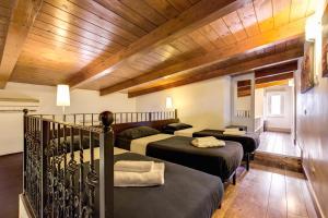 a room with four beds and a wooden ceiling at Aurelia Vatican Apartments in Rome