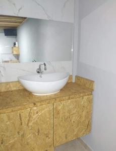 a bathroom with a white sink on a wooden counter at Alojamiento Loft céntrico in Esperanza