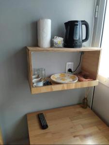 a shelf with a plate and a coffee pot and a remote control at Alojamiento Loft céntrico in Esperanza +3 photos