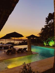 une piscine avec chaises et parasols dans un complexe hôtelier dans l'établissement Casa de Piedra, à Acapulco