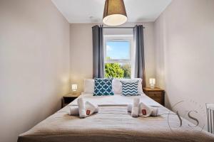 a bedroom with a large bed with a window at 4BR Family Home in 89 Highgate with Jacuzzi, Games Room & Free Parking Near Birmingham in Walsall
