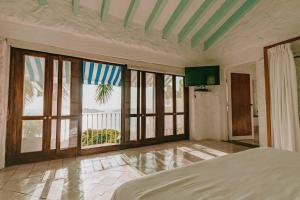 une chambre avec de grandes fenêtres et un lit dans une pièce dans l'établissement Casa de Piedra, à Acapulco