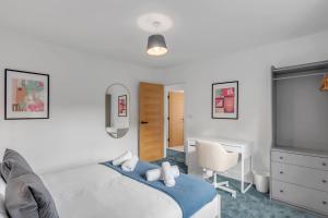 a bedroom with a bed and a desk and a chair at 4 King Beds & Private Backyard in Ringland