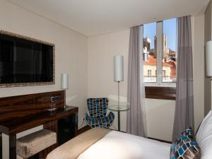 a living room with a television and a bed at TURIM Terreiro do Paço Hotel in Lisbon