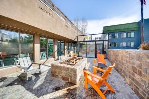 a patio with chairs and a fire pit in front of a building at 2 Mi to Winter Park Resort: Condo w/ Pool Access! in Winter Park