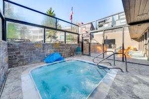 a large swimming pool in a house with glass windows at 2 Mi to Winter Park Resort: Condo w/ Pool Access! in Winter Park