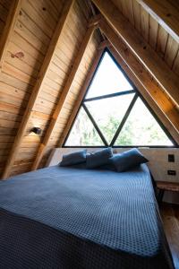 a bed in a room with a large window at Jungle Cottage in El Valle +15 photos