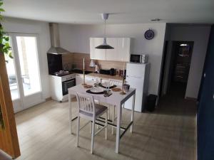 a kitchen with a white table and chairs in a room at Love Room Emoi de toi in Sigean